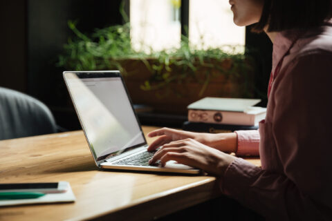 Woman typing on laptop in cafe