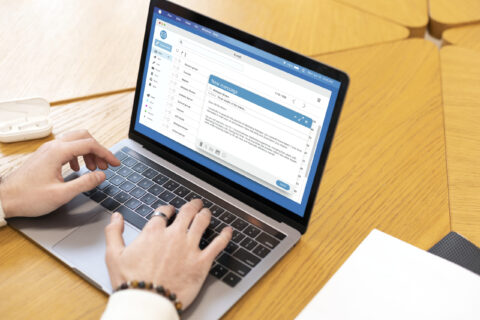 Hands typing an email on laptop